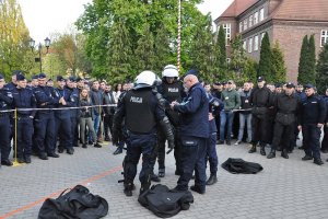 Policjanci zakładający na siebie elementy wyposażenia pezet.