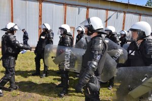 Policjanci formują pododdział w szyku zwartym.