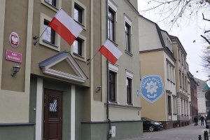 Budynek sądu okręgowego. W tle kolejny budynek z logo szkoły policji namalowanym na ścianie bocznej.