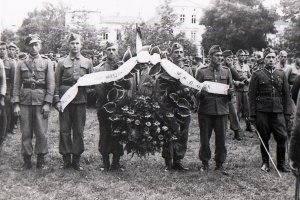 Pięciu słuchaczy trzyma duży wieniec z napisem &quot;Bohaterom Powstania Warszawskiego - ce wu em o Słupsk&quot;.