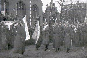 Na pierwszym planie maszeruje poczet sztandarowy z nowowręczonym sztandarem.