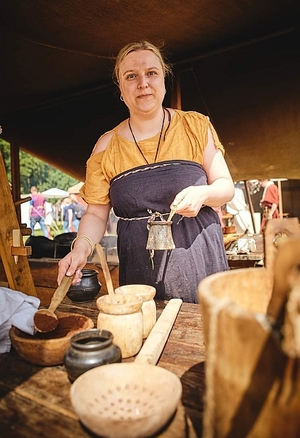 Kobieta w historycznej kuchni polowej z czasów cesarstwa rzymskiego.