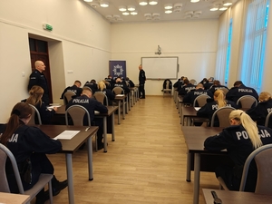 Policjanci siedzący przy biurkach rozwiązujący test