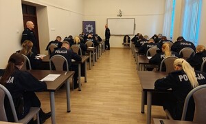 Słuchacze siedzący w ławkach i rozwiązujący test końcowy szkolenia