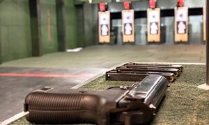 Zdjęcie pistoletu P-83 na tle kulochwytów na strzelnicy zamkniętej