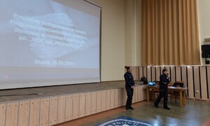 Policjantki stojące pod sceną auli