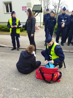 Policjanci udzielający pomocy na miejscu zdarzenia drogowego