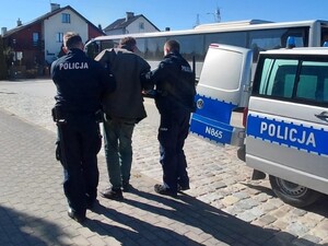 policjanci prowadzący zatrzymanego
