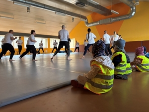 przedszkolaki oglądające policjantów na zajęciach z wychowania fizycznego