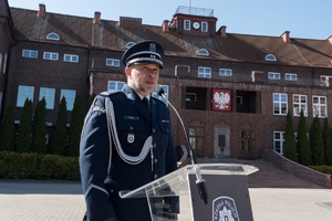 przemawiający Komendant na tle głównego budynku dydaktycznego Szkoły