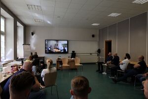 policjanci przyglądający się przesłuchaniu