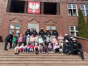 przedszkolaki z funkcjonariuszami Policji na schodach głównego budynku dydaktycznego