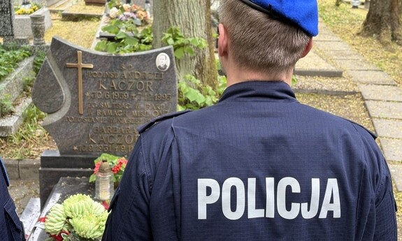 Policjant przy grobie poległego funkcjonariusza Policji