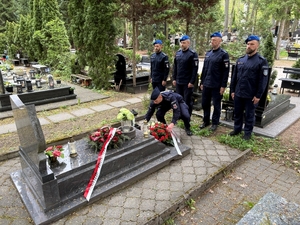 Policjant przy grobie poległego funkcjonariusza Policji