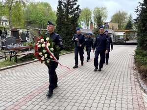 policjanci zmierzający do grobu poległego funkcjonariusza Policji