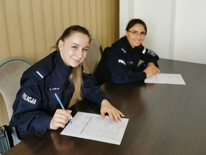 policjanci siedzący w ławkach i rozwiązujący test