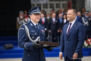 Komendant Szkoły Policji w Słupsku z wręczoną przez Prezydenta RP flagą.